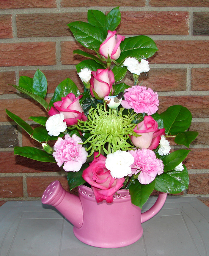 Assorted colourful flowers in a pink container